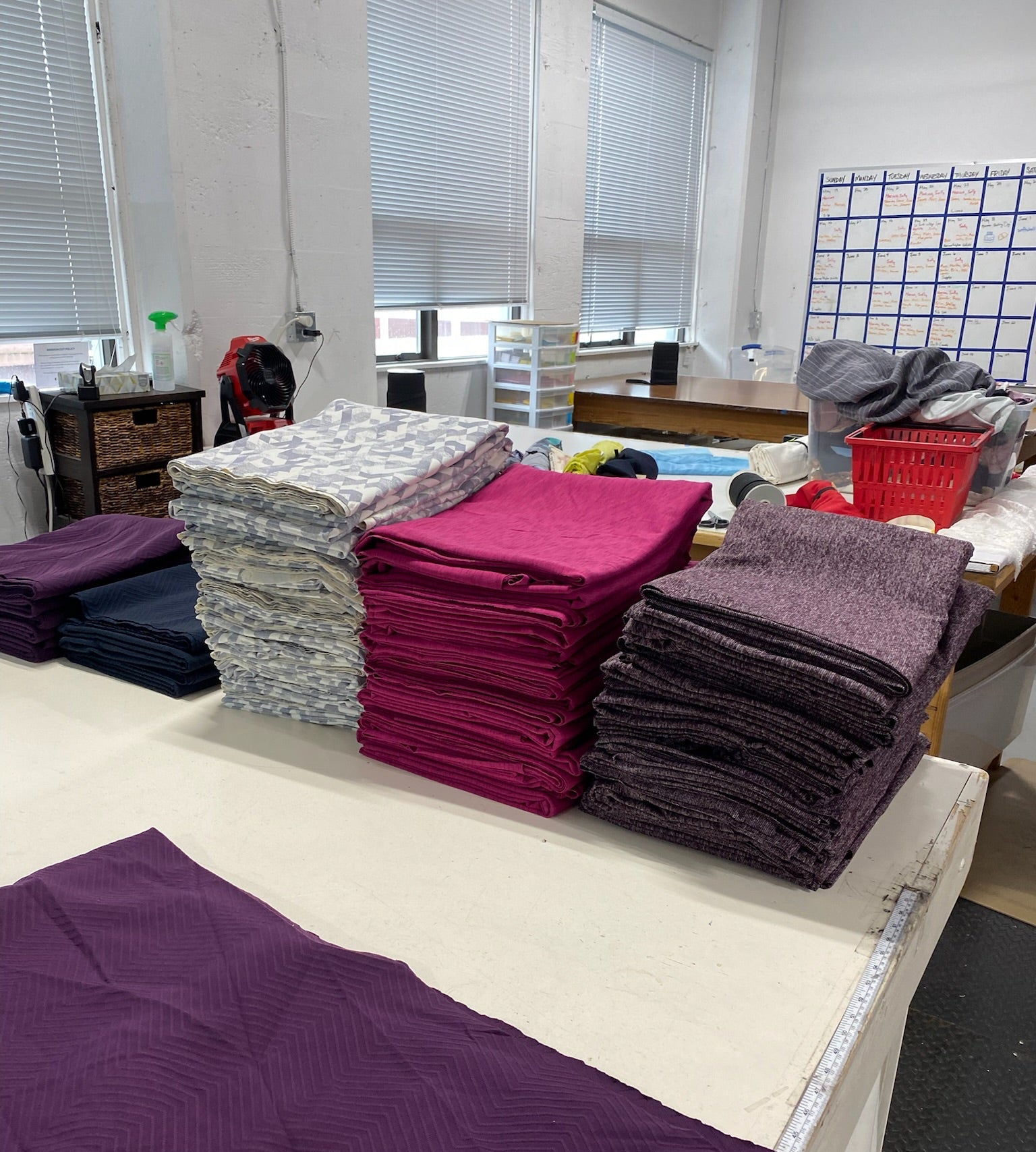 Stacks of fabric on a table in a workshop setting
